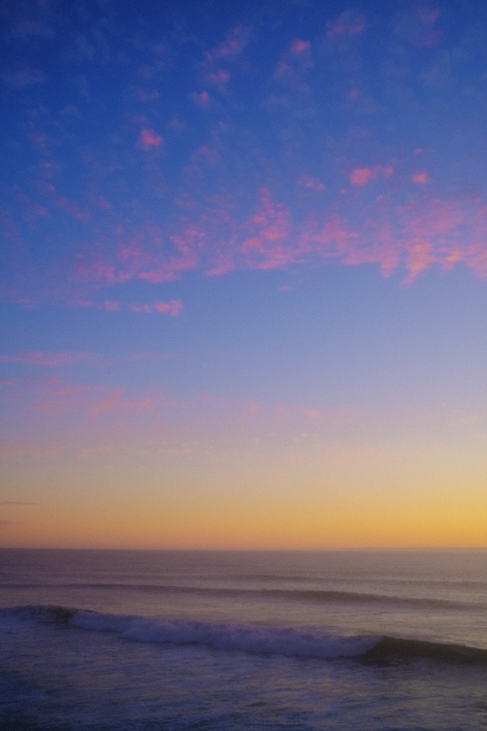 San Francisco sunset with pink clouds over waves